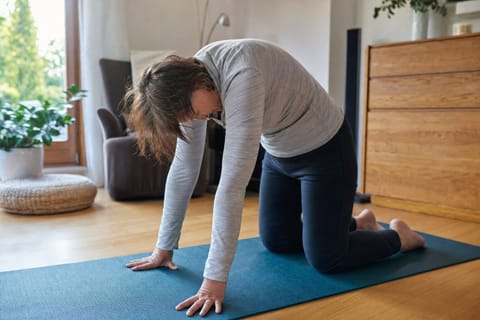 Gesundheits- und Rückentraining zu Hause Tim Haaf leitet eine Frau bei einer Rückenübung auf der Matte an