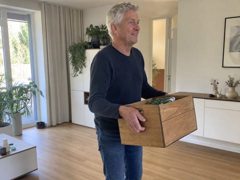 Vitaler Best Ager hebt mühelos eine Kiste, aufrecht und kraftvoll im Alltag